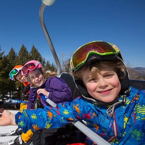 Kids smiling on chairlift